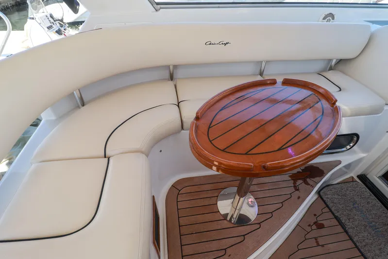 Aphrodite Yacht Photos Pics Luxurious seating area on 2004 Chris-Craft Roamer 40 yacht with elegant wooden table.