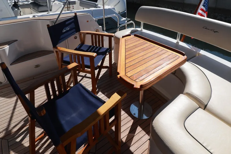 Aphrodite Yacht Photos Pics Luxury seating area on 2004 Chris-Craft Roamer 40 yacht with wooden table and chairs.