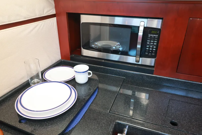Aphrodite Yacht Photos Pics Galley kitchen in 2004 Chris-Craft Roamer 40 with microwave and dishware.