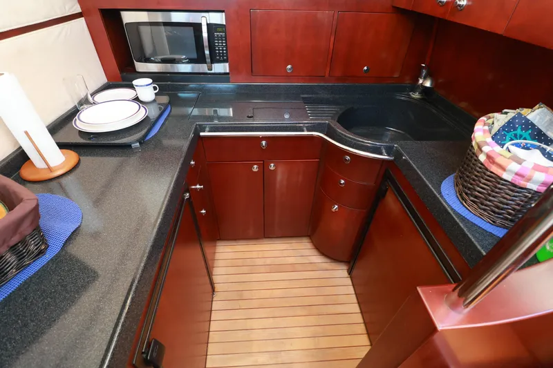 Aphrodite Yacht Photos Pics Luxurious 2004 Chris-Craft Roamer 40 yacht kitchen with wood cabinetry and modern appliances.