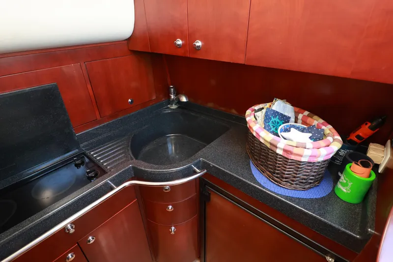 Aphrodite Yacht Photos Pics 2004 Chris-Craft Roamer 40 yacht kitchen with wooden cabinets and black countertop.