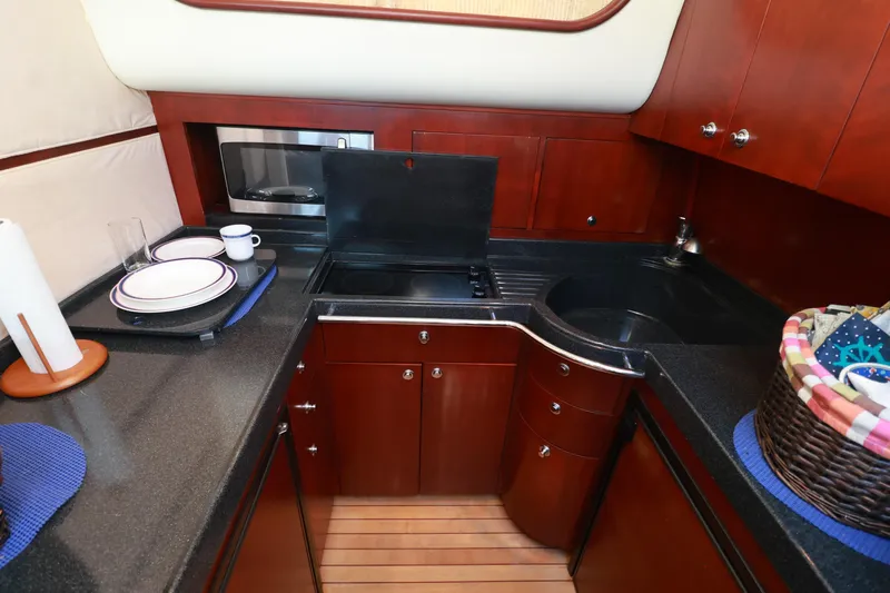 Aphrodite Yacht Photos Pics Luxurious 2004 Chris-Craft Roamer 40 yacht kitchen with sleek cabinetry and modern appliances.