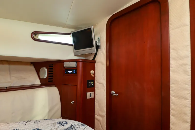 Aphrodite Yacht Photos Pics Interior cabin of 2004 Chris-Craft Roamer 40 with wood paneling and mounted TV.