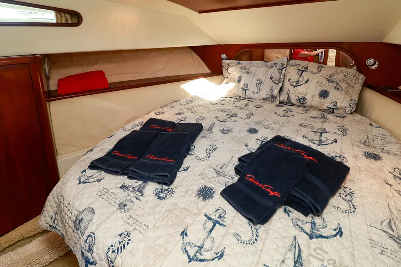 Aphrodite Yacht Photos Pics Luxurious cabin interior of 2004 Chris-Craft Roamer 40 with nautical-themed bedding and towels.
