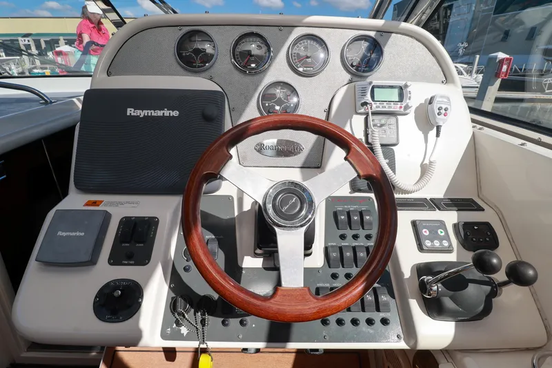 Aphrodite Yacht Photos Pics Control panel of 2004 Chris-Craft Roamer 40 with Raymarine navigation system and wooden steering wheel.