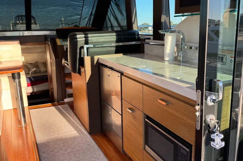 After Glow Yacht Photos Pics Interior of 2016 Tiara Yachts 39 Coupe, featuring modern kitchen and seating area.