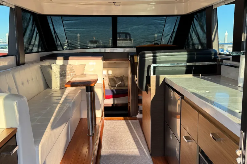 After Glow Yacht Photos Pics Interior of 2016 Tiara Yachts 39 Coupe, featuring modern seating and kitchen area.
