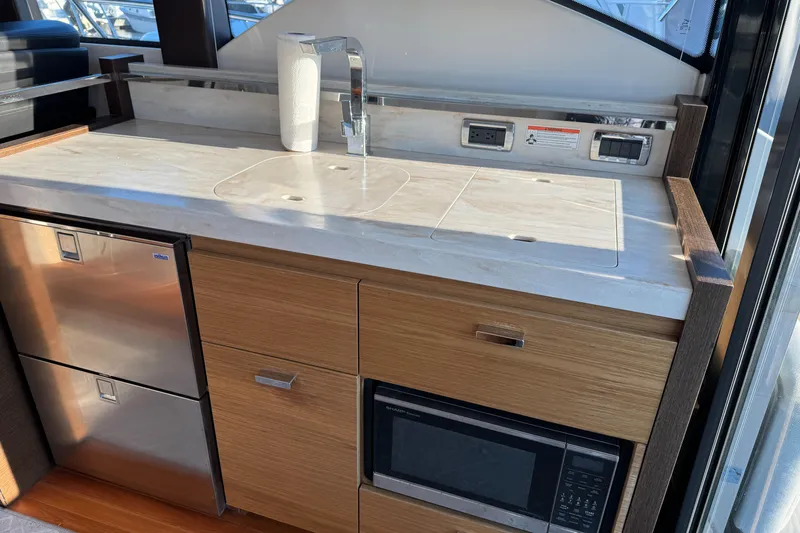 After Glow Yacht Photos Pics Modern kitchen area in 2016 Tiara Yachts 39 Coupe with sink, microwave, and fridge.