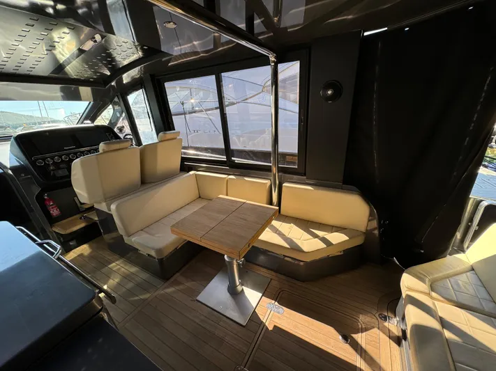 Anahita Yacht Photos Pics Interior of 2017 SACS Rebel 47 yacht with beige seating and wooden table.