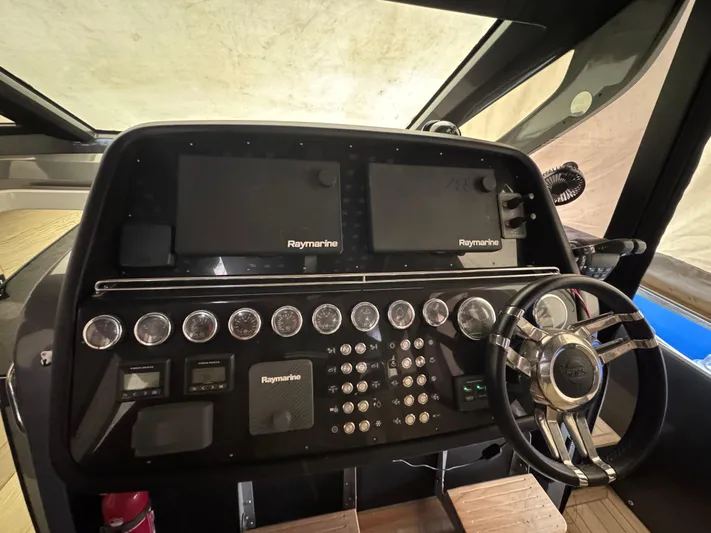 Anahita Yacht Photos Pics Control panel of 2017 SACS Rebel 47 boat with Raymarine displays and steering wheel.