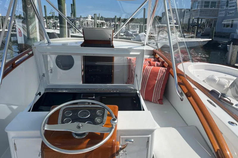 Charmer Yacht Photos Pics 1985 Rybovich Walkaround boat cockpit with steering wheel and marina view.