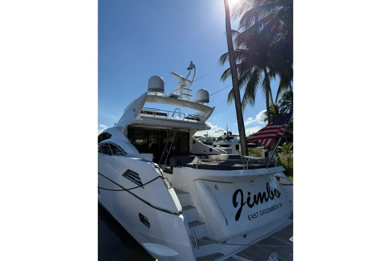 Jimbo Yacht Photos Pics 2012 Sunseeker Predator Sport Yacht 74 docked, with palm trees and American flag in background.