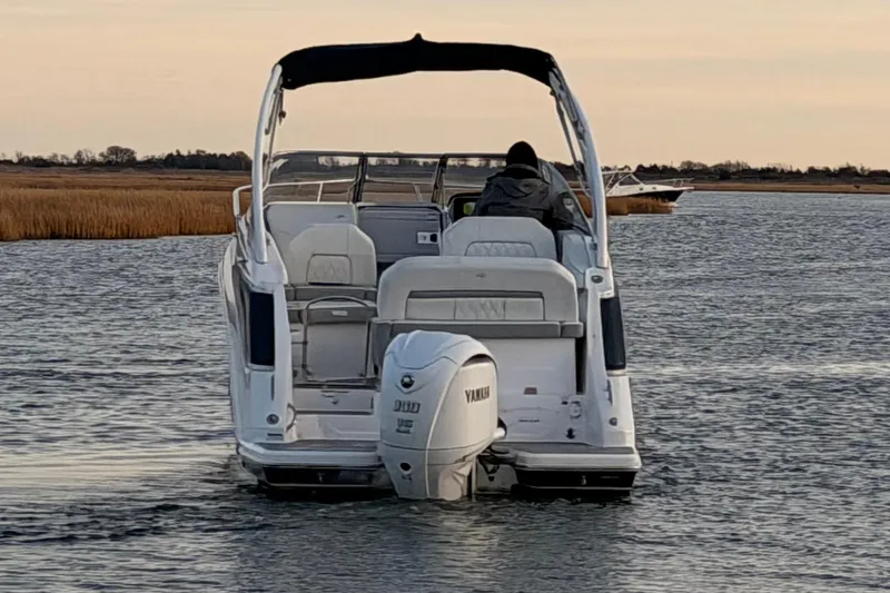  Yacht Photos Pics 2022 Regal 26 XO boat cruising on calm water at sunset.