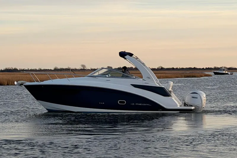  Yacht Photos Pics 2022 Regal 26 XO boat cruising on calm water at sunset.