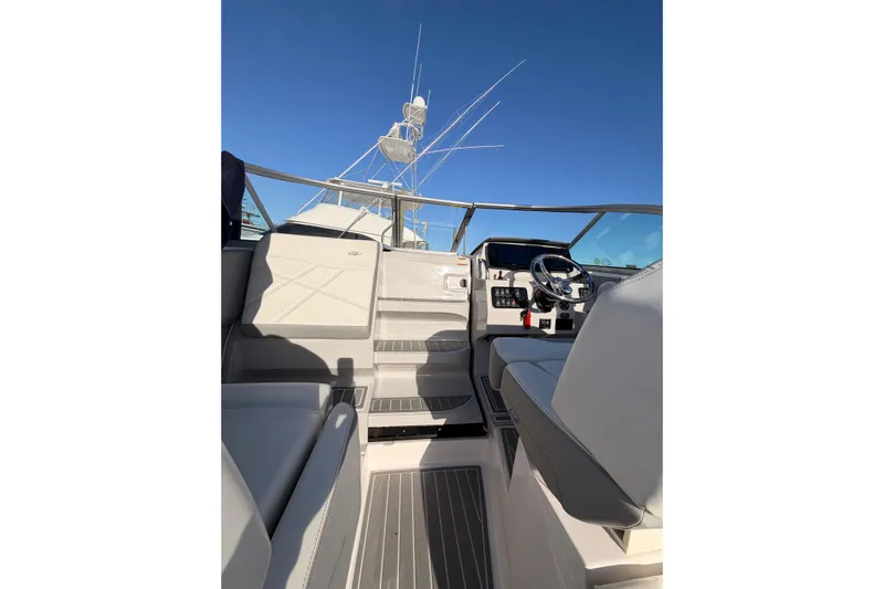  Yacht Photos Pics 2022 Regal 26 XO boat interior with steering wheel and seating under clear blue sky.