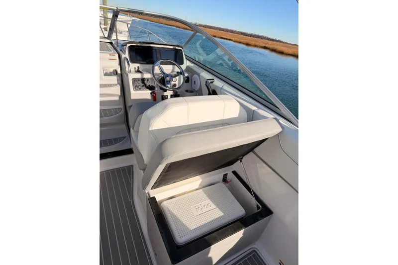  Yacht Photos Pics 2022 Regal 26 XO boat helm with storage compartment, steering wheel, and water view.