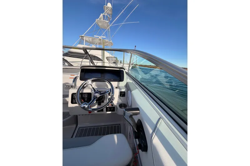  Yacht Photos Pics 2022 Regal 26 XO boat helm with steering wheel and controls, on calm water.