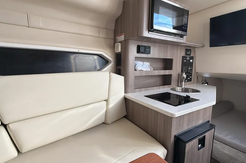  Yacht Photos Pics 2022 Regal 26 XO boat interior with kitchenette and seating area.