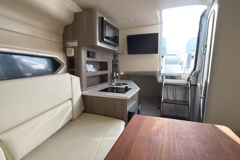  Yacht Photos Pics 2022 Regal 26 XO boat interior with kitchenette, seating, and ladder access.