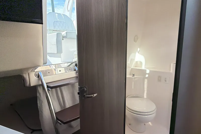  Yacht Photos Pics 2022 Regal 26 XO boat interior with compact bathroom and seating area.