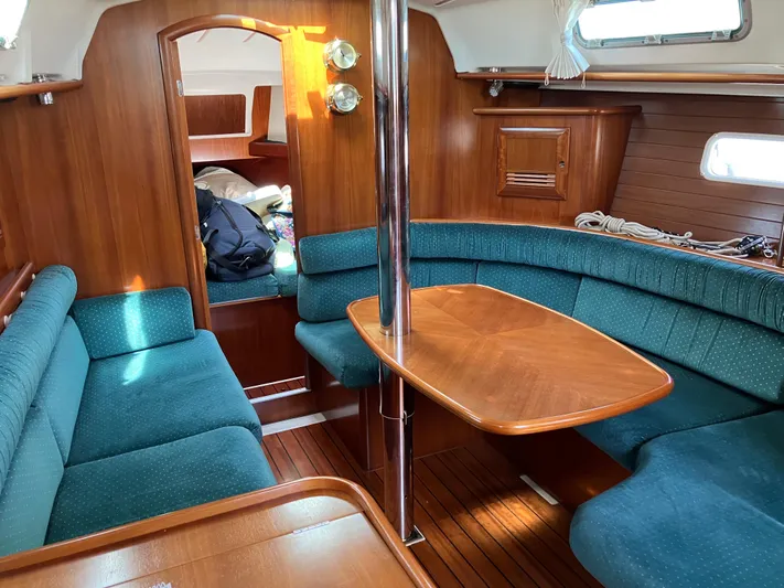Egret Yacht Photos Pics Interior of 2001 Beneteau Oceanis Clipper 361 sailboat with wooden furnishings and teal seating.