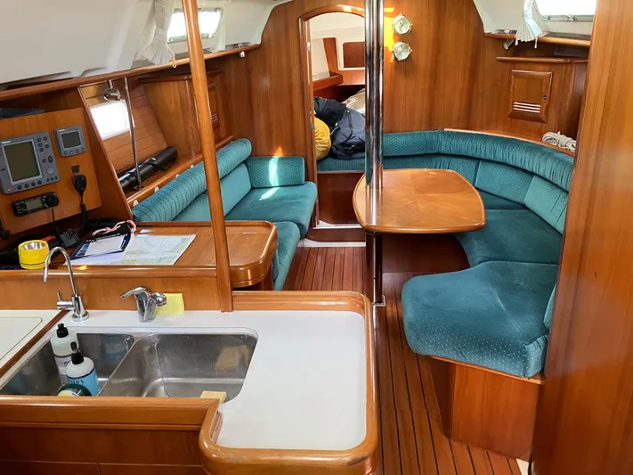 Egret Yacht Photos Pics Interior of 2001 Beneteau Oceanis Clipper 361 yacht with wood finish and teal seating.