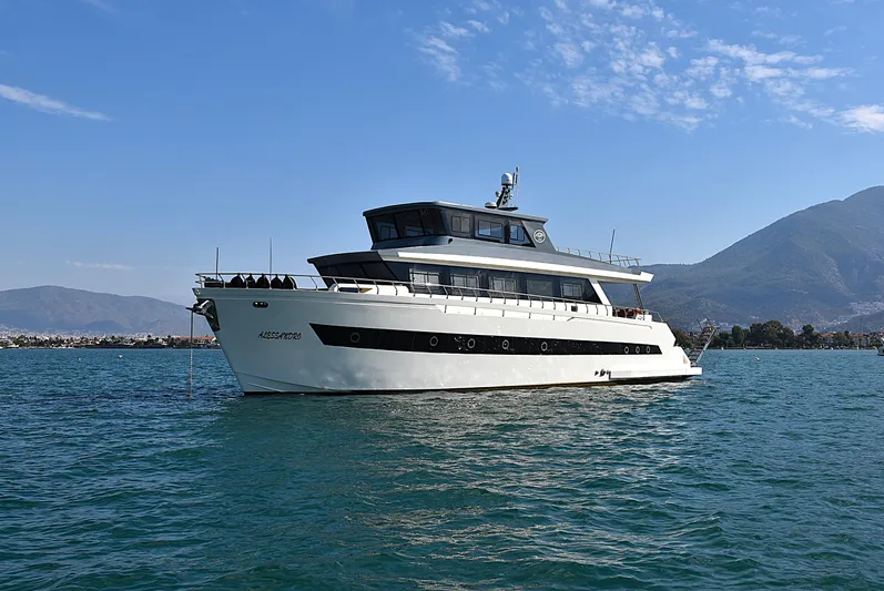  Yacht Photos Pics Modern 2024 Custom Trawler RPH yacht on calm water with mountainous backdrop.
