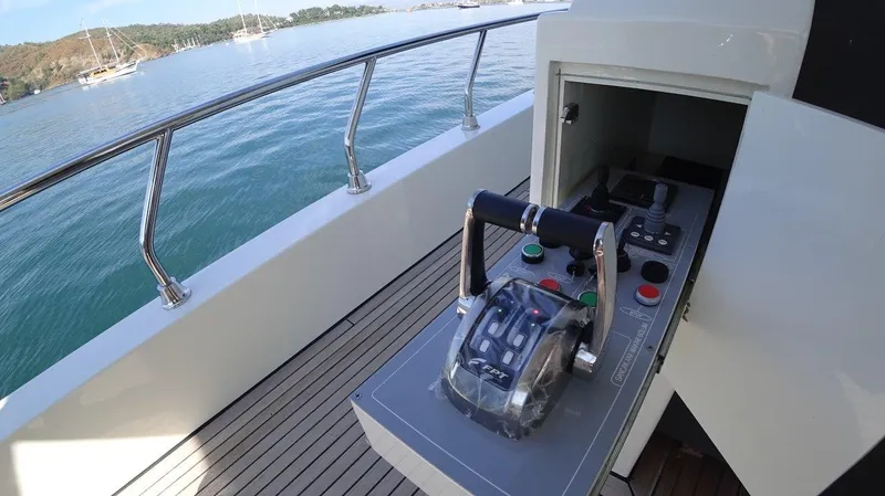  Yacht Photos Pics Modern Trawler RPH 2024 control panel on deck, overlooking serene waters and distant boats.