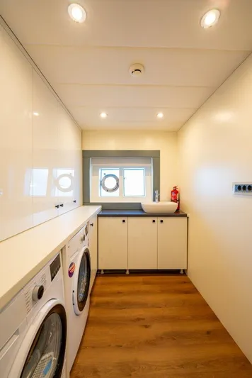  Yacht Photos Pics Laundry room on 2024 Custom Modern Trawler RPH with washer, dryer, and porthole window.