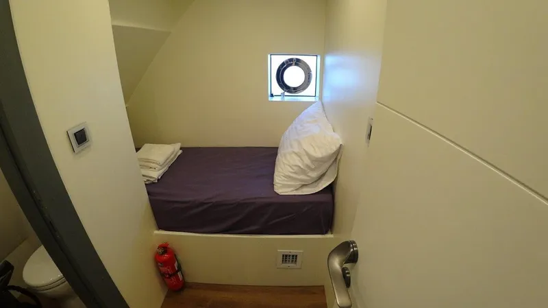  Yacht Photos Pics Small cabin interior on 2024 Custom Modern Trawler RPH, featuring a bed and porthole window.