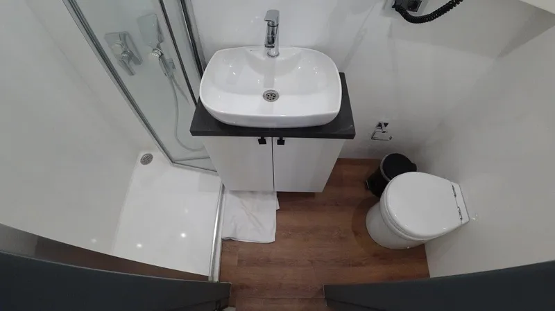  Yacht Photos Pics Modern Trawler RPH 2024 bathroom with shower, sink, and toilet, featuring sleek design.