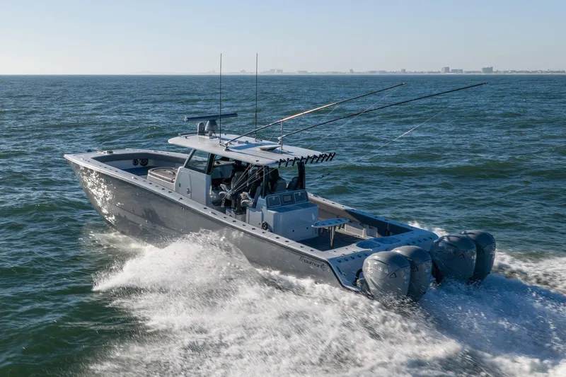 Jackie B Yacht Photos Pics 2024 Freeman 47 boat cruising on open water with fishing rods and powerful engines.