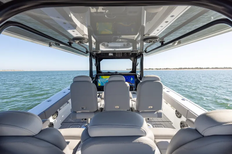 Jackie B Yacht Photos Pics Interior view of 2024 Freeman 47 boat, featuring modern seating and ocean backdrop.