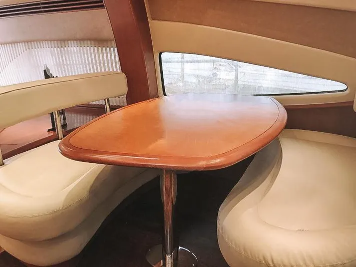  Yacht Photos Pics Luxurious interior of 2007 Aicon 52 yacht with elegant wooden table and plush seating.