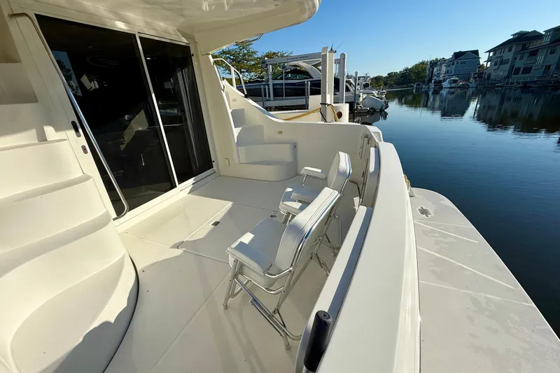  Yacht Photos Pics 2009 Carver 43 Super Sport yacht deck with chairs, docked by calm waters.