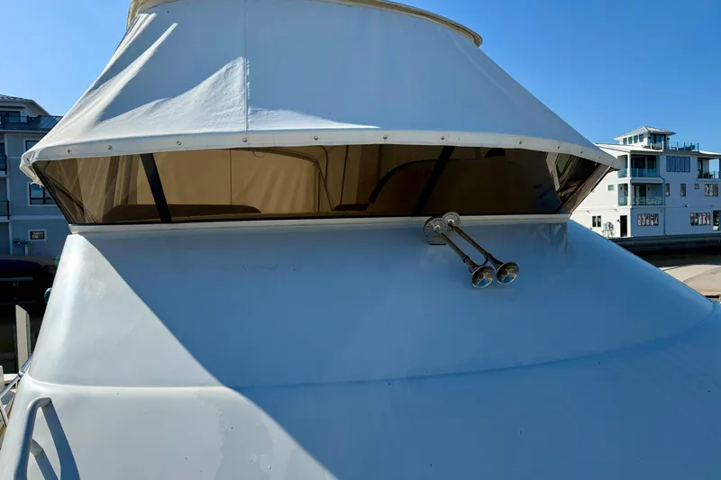  Yacht Photos Pics 2009 Carver 43 Super Sport yacht with white canopy and dual horns, docked near modern buildings.