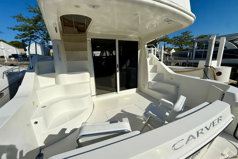  Yacht Photos Pics 2009 Carver 43 Super Sport yacht deck with seating and stairs, docked under clear skies.