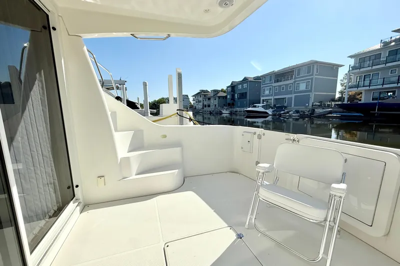  Yacht Photos Pics 2009 Carver 43 Super Sport yacht deck with chair, docked near waterfront homes.