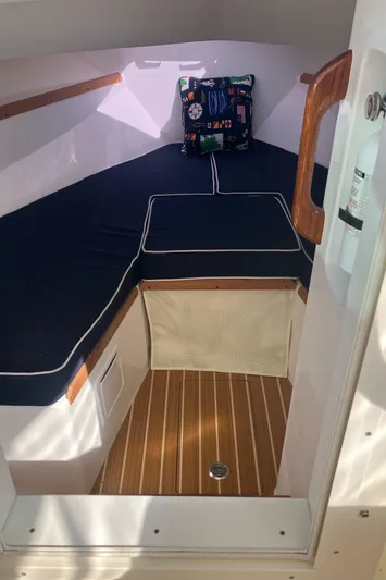  Yacht Photos Pics 2019 Hunt Yachts Harrier 26 cabin interior with cushioned seating and wooden flooring.
