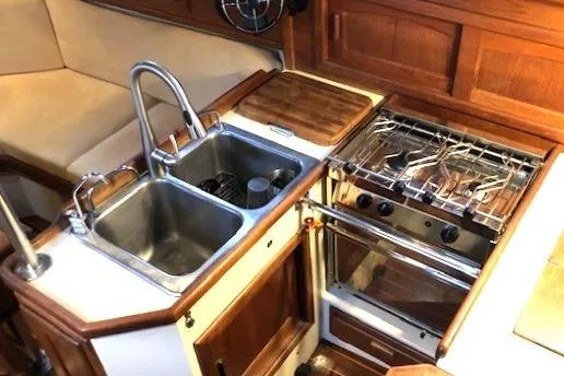 Sapphire Yacht Photos Pics 1992 Pacific Seacraft 37 yacht kitchen with sink, stove, and wooden cabinetry.