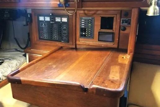 Sapphire Yacht Photos Pics Navigation station of a 1992 Pacific Seacraft 37 sailboat with wooden desk and control panels.