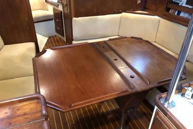Sapphire Yacht Photos Pics Interior of 1992 Pacific Seacraft 37 sailboat with wooden table and cushioned seating.