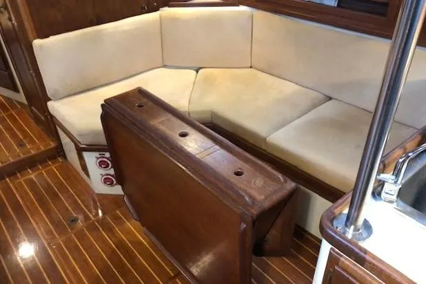 Sapphire Yacht Photos Pics Interior of 1992 Pacific Seacraft 37 sailboat with wooden table and cushioned seating.