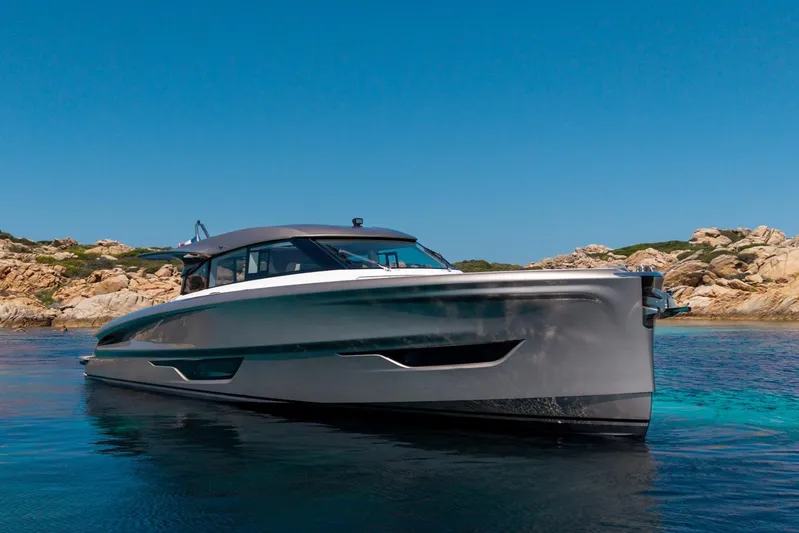  Yacht Photos Pics 2026 Solaris Power 52 Coupe yacht on clear blue water near rocky shoreline.