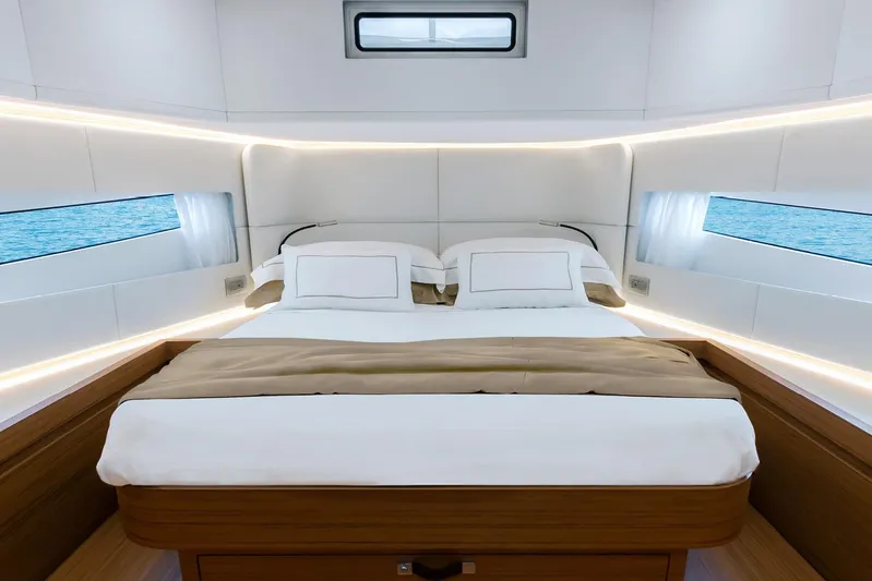  Yacht Photos Pics Luxurious bedroom interior of 2026 Solaris Power 52 Coupe yacht, featuring elegant bedding and ambient lighting.