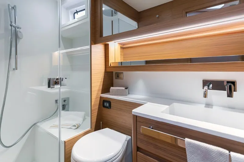  Yacht Photos Pics Luxurious bathroom interior of 2026 Solaris Power 52 Coupe yacht, featuring modern fixtures and wood accents.