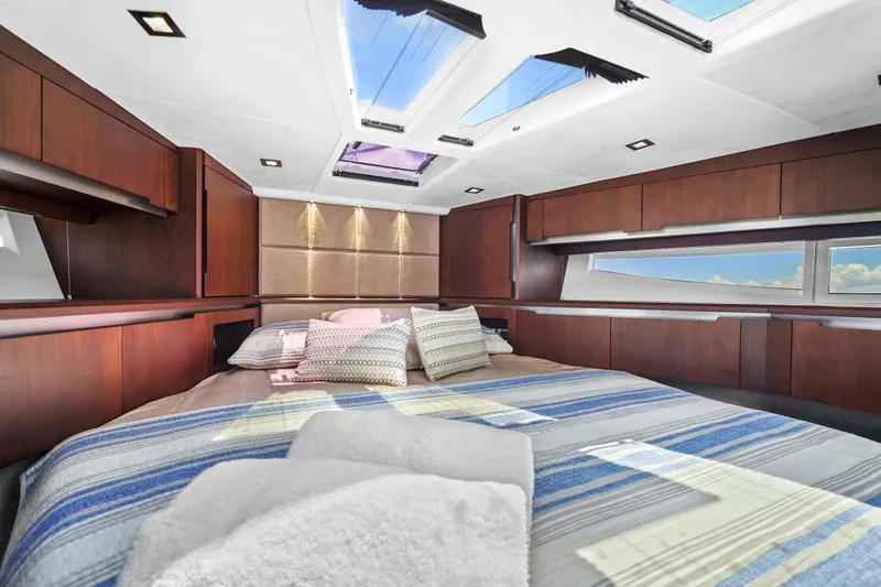 Good Vibes Yacht Photos Pics Luxurious bedroom interior of 2022 Galeon 470 Sky yacht with skylights and wooden cabinetry.