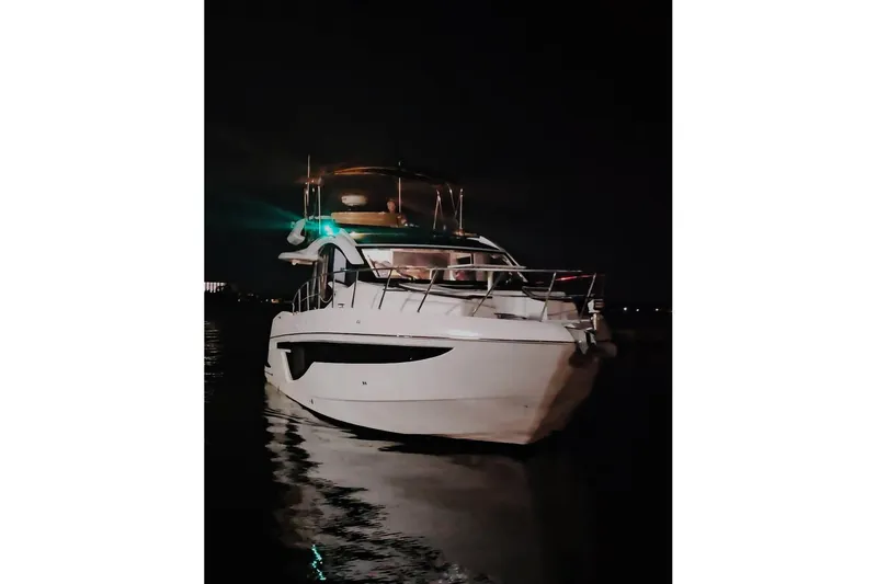 Good Vibes Yacht Photos Pics 2022 Galeon 470 Sky yacht illuminated at night on calm water.