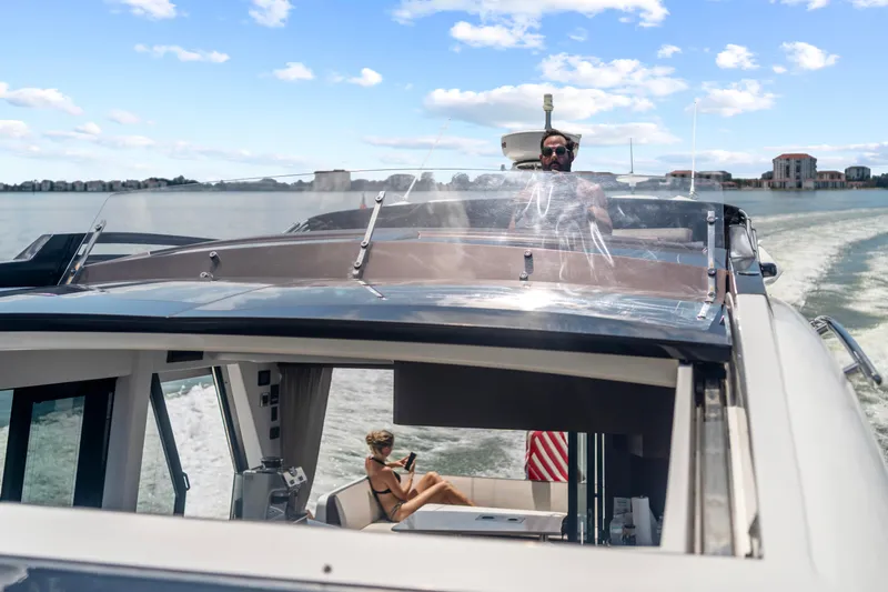 Good Vibes Yacht Photos Pics 2022 Galeon 470 Sky yacht cruising with passengers, clear skies, and waterfront view.