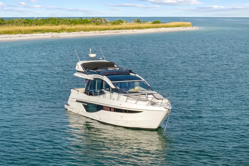 Good Vibes Yacht Photos Pics 2022 Galeon 470 Sky yacht cruising near a scenic shoreline.